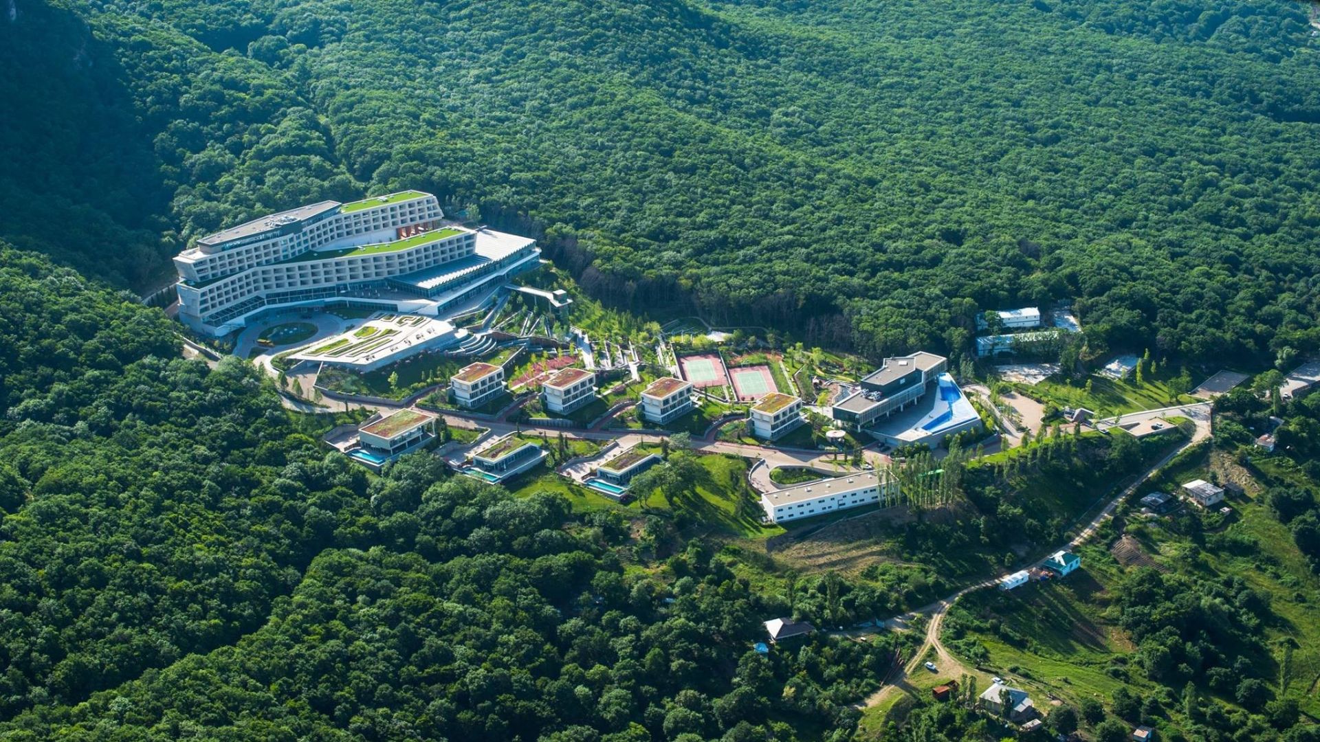 A forest-surrounded hotel and villa complex in the supplied accommodation image